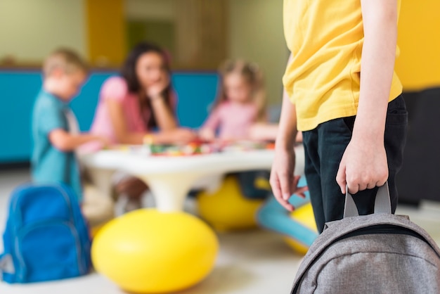 Niño sosteniendo una mochila con espacio de copia