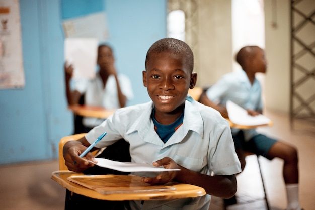 Niño sosteniendo papel blanco en la escuela