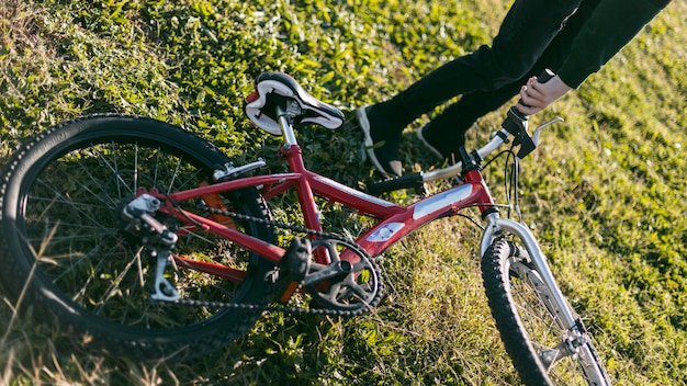 Niño sosteniendo su bicicleta sobre el césped