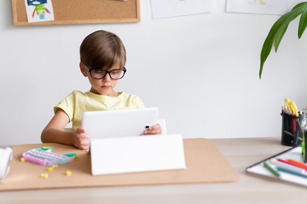 Foto gratuita niño sosteniendo tableta tiro medio