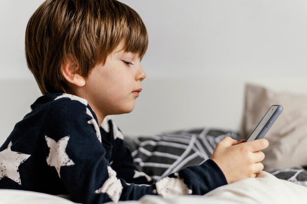 Niño sosteniendo un teléfono de tiro medio