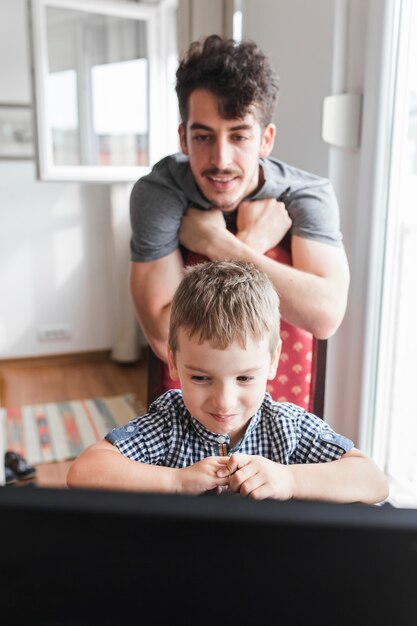 Niño y su padre mirando portátil