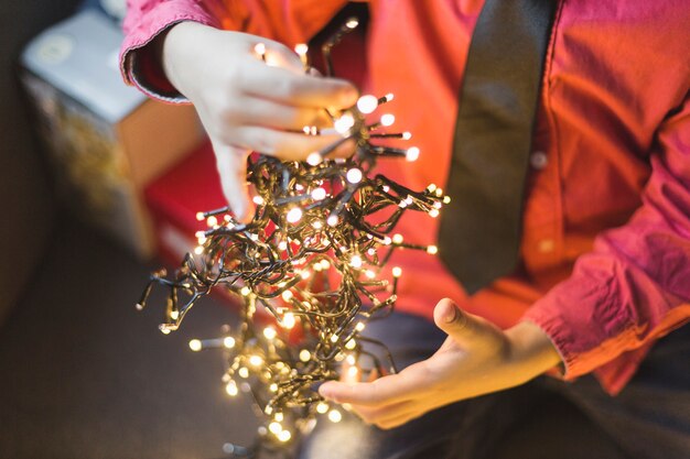 Niño sujetando luces de navidad