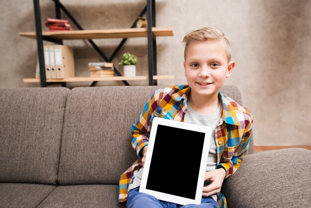 Niño con tableta en sofá