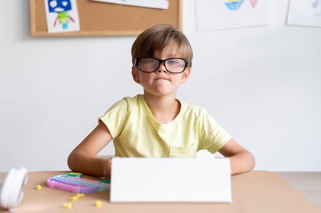 Foto gratuita niño con tableta de tiro medio