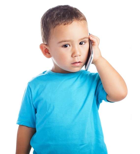 Niño con un teléfono en la oreja
