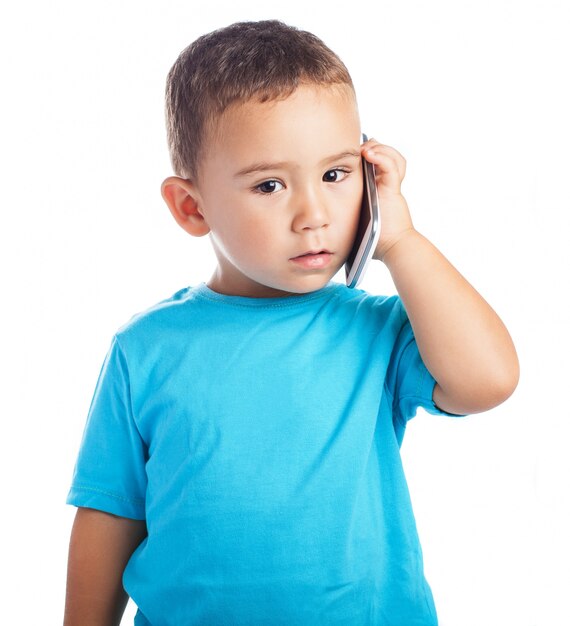 Niño con un teléfono en la oreja