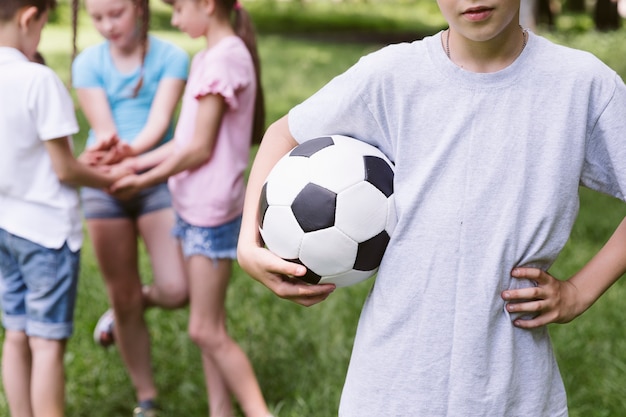 Foto gratuita niño, tenencia, un, pelota del balompié