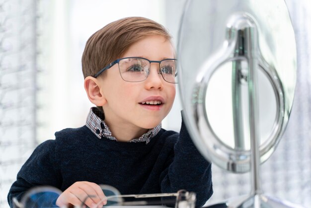 Niño en la tienda probándose gafas