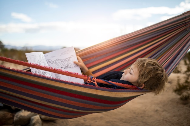 Niño de tiro completo acostado en una hamaca