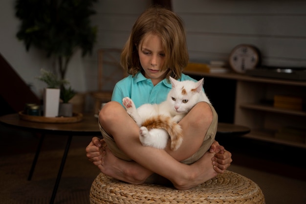 Niño de tiro completo con adorable gato