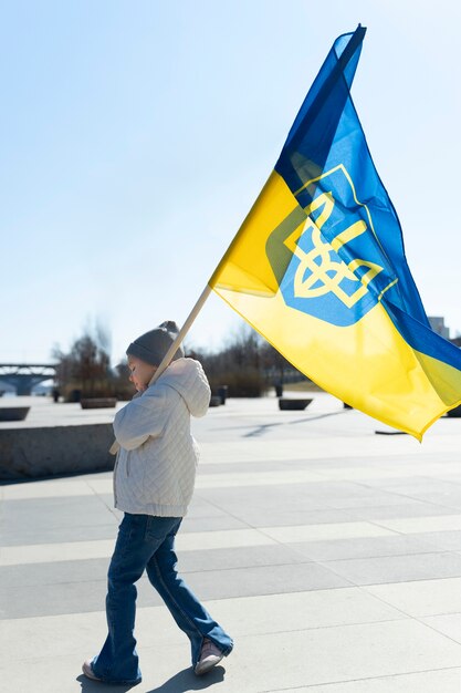 Niño de tiro completo con bandera ucraniana