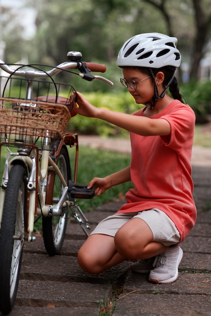 Niño de tiro completo en bicicleta al aire libre