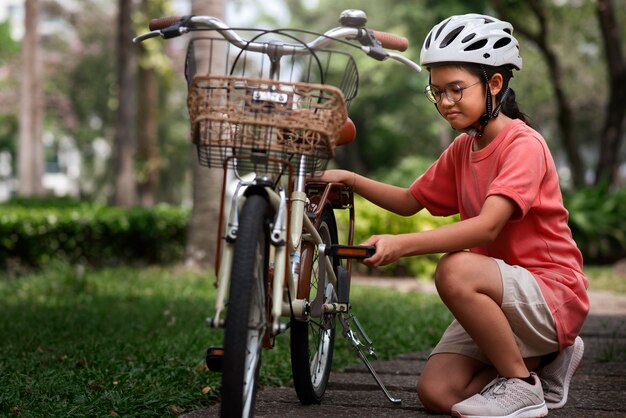 Niño de tiro completo en bicicleta al aire libre