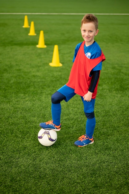 Niño de tiro completo en el campo de fútbol