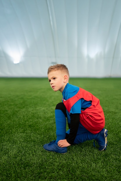 Niño de tiro completo en el campo de fútbol