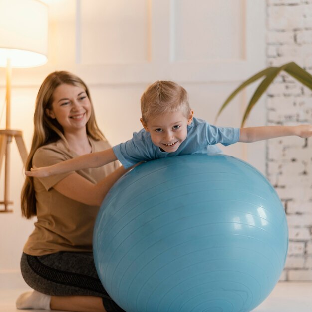 Niño de tiro completo en ejercicio de pelota de gimnasio