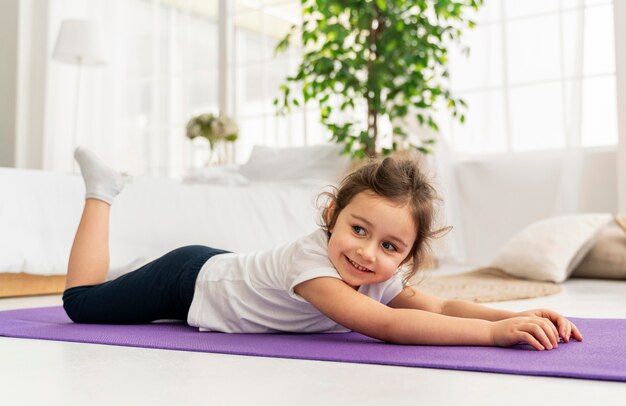 Niño de tiro completo en estera de yoga