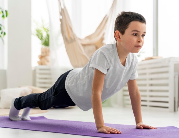 Niño de tiro completo haciendo plancha