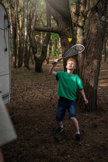 Niño de tiro completo jugando bádminton