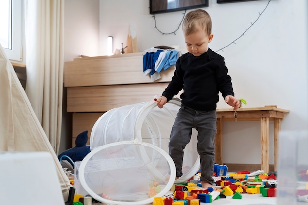 Niño de tiro completo jugando en casa