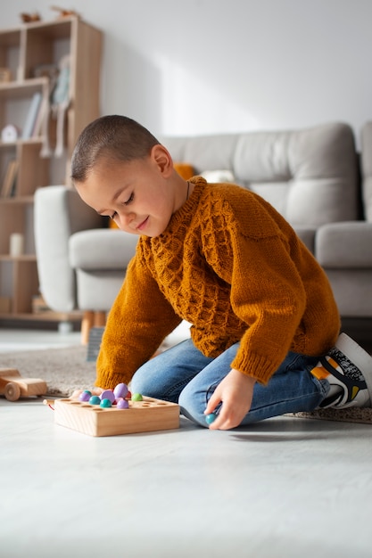 Niño de tiro completo jugando en casa