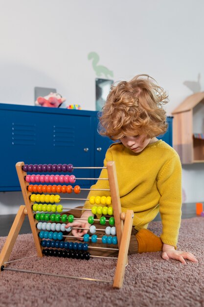 Niño de tiro completo jugando con juguete colorido