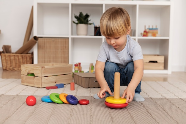 Foto gratuita niño de tiro completo jugando con juguete de madera