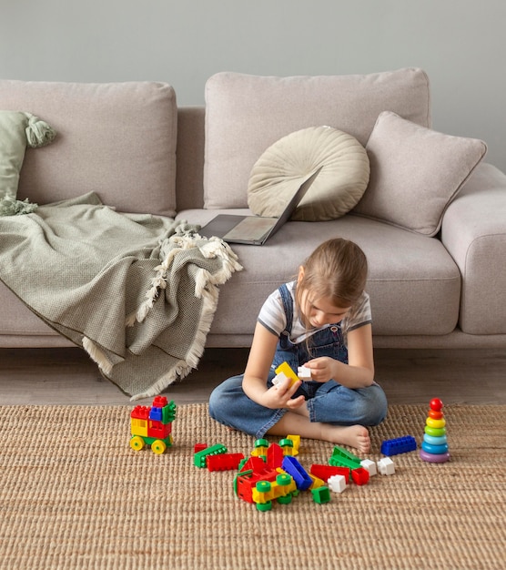 Niño de tiro completo jugando en el piso