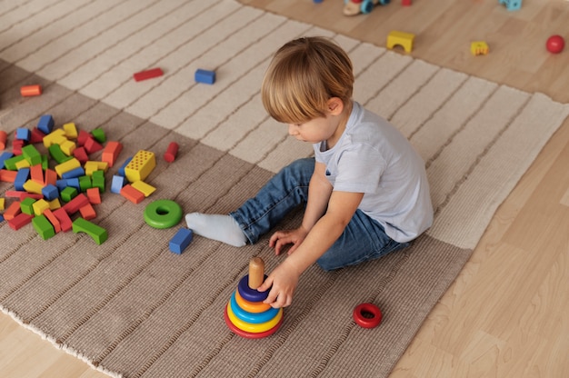 Niño de tiro completo jugando en el piso