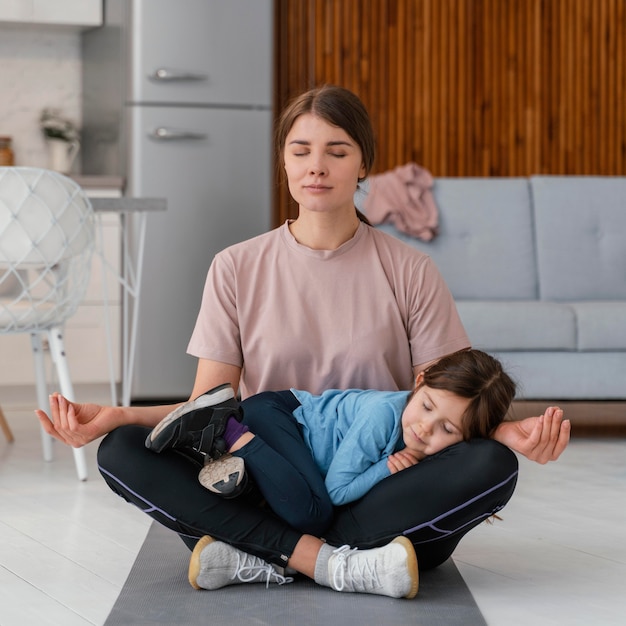 Foto gratuita niño de tiro completo y madre meditando