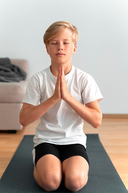 Niño de tiro completo meditando