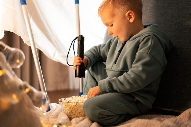 Foto gratuita niño de tiro completo con palomitas de maíz