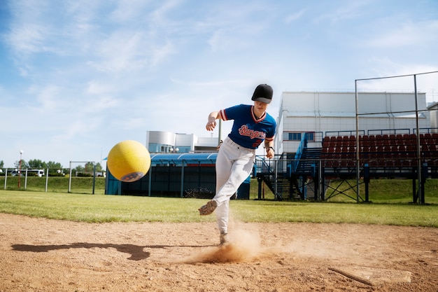 Foto gratuita niño de tiro completo pateando la pelota amarilla