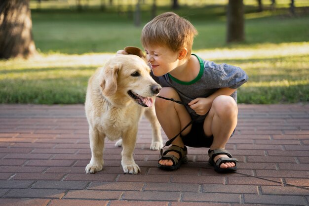 Niño de tiro completo y perro sonriente