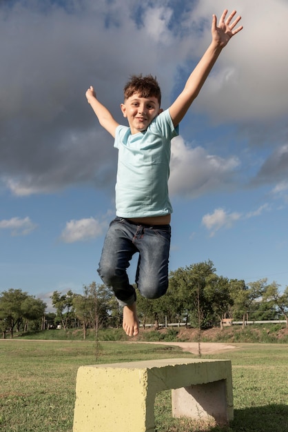 Foto gratuita niño de tiro completo saltando al aire libre