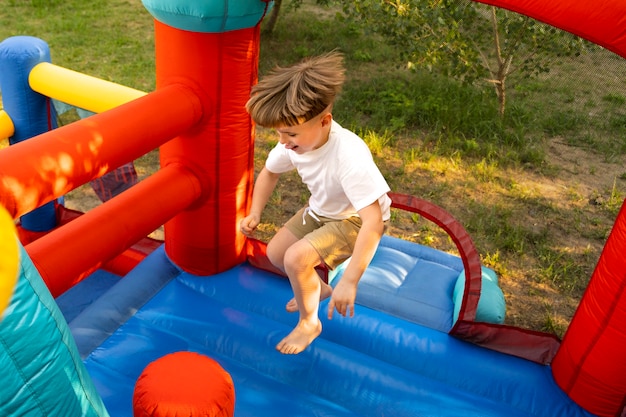 Niño de tiro completo saltando en casa de rebote