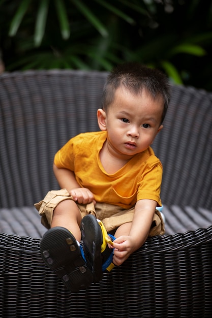 Foto gratuita niño de tiro completo sentado al aire libre