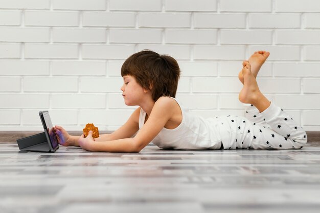 Foto gratuita niño de tiro completo sentado en el piso