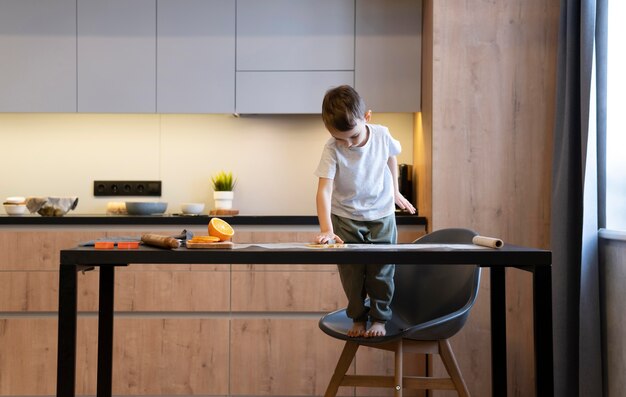 Niño de tiro completo solo en la cocina