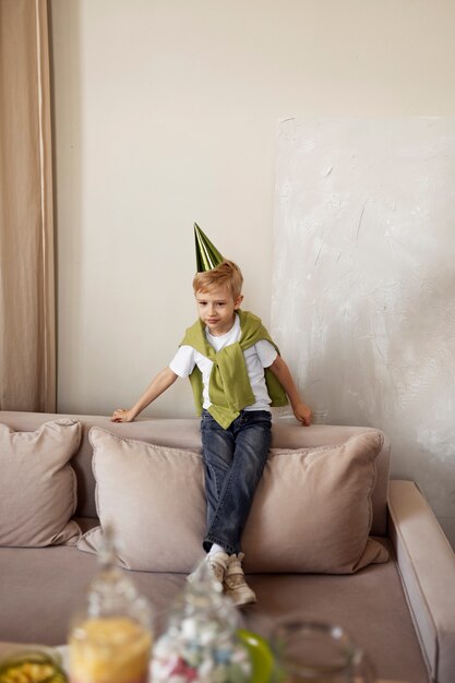 Niño de tiro completo con sombrero de fiesta