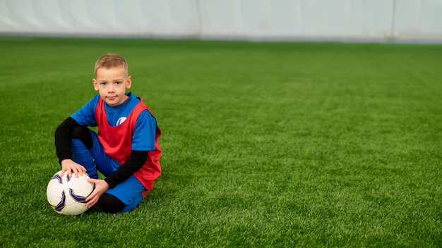 Niño de tiro completo sosteniendo pelota