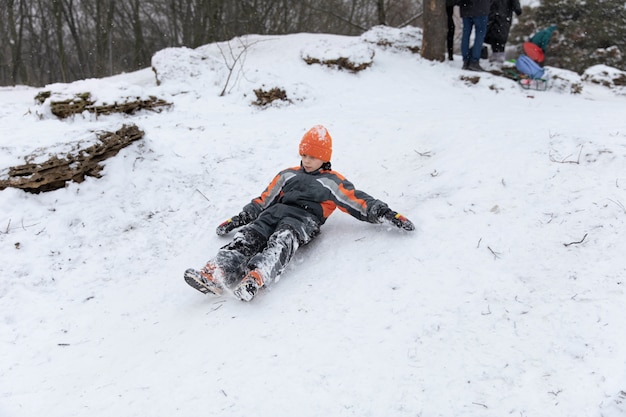 Niño de tiro completo tendido en la nieve