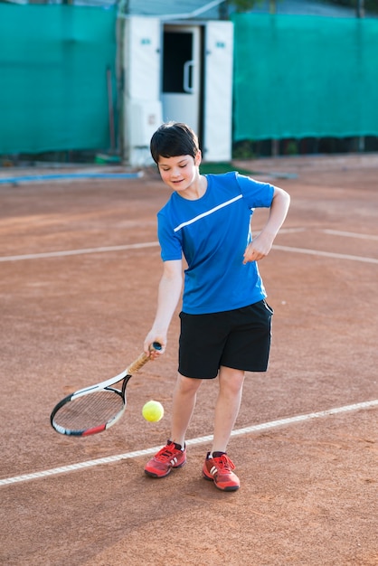 Foto gratuita niño tiro largo jugando tenis