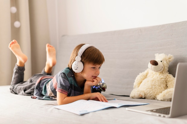 Niño de tiro largo que asiste a cursos de la escuela virtual