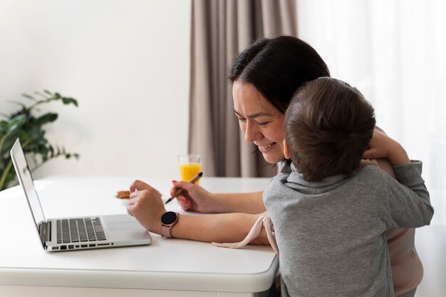 Niño de tiro medio abrazando a la madre