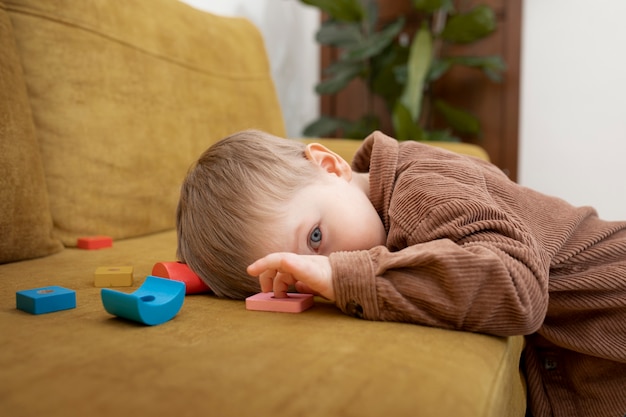 Niño de tiro medio acostado en el sofá