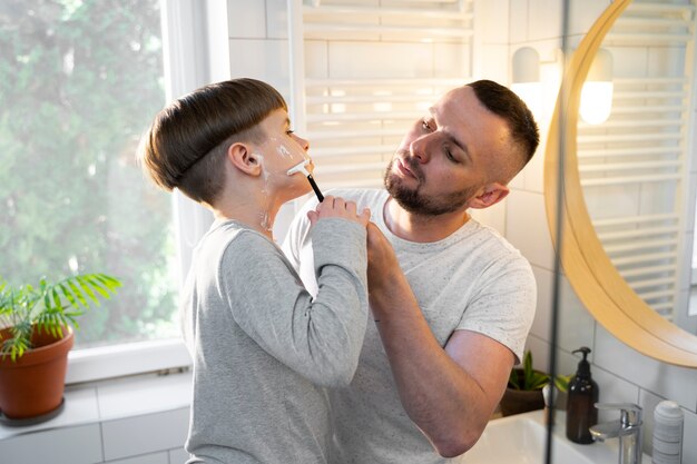 Niño de tiro medio aprendiendo a afeitarse