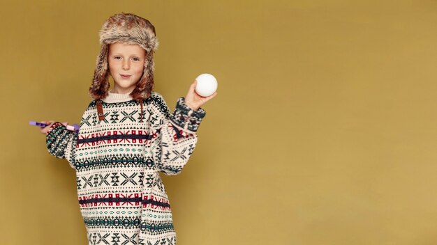 Niño de tiro medio con bola de nieve y espacio de copia