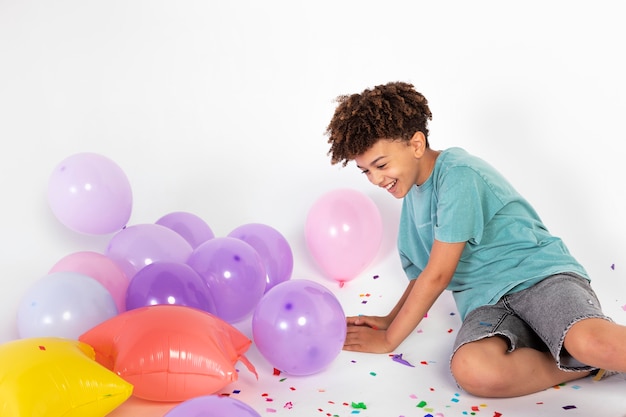 Foto gratuita niño de tiro medio celebrando con globos